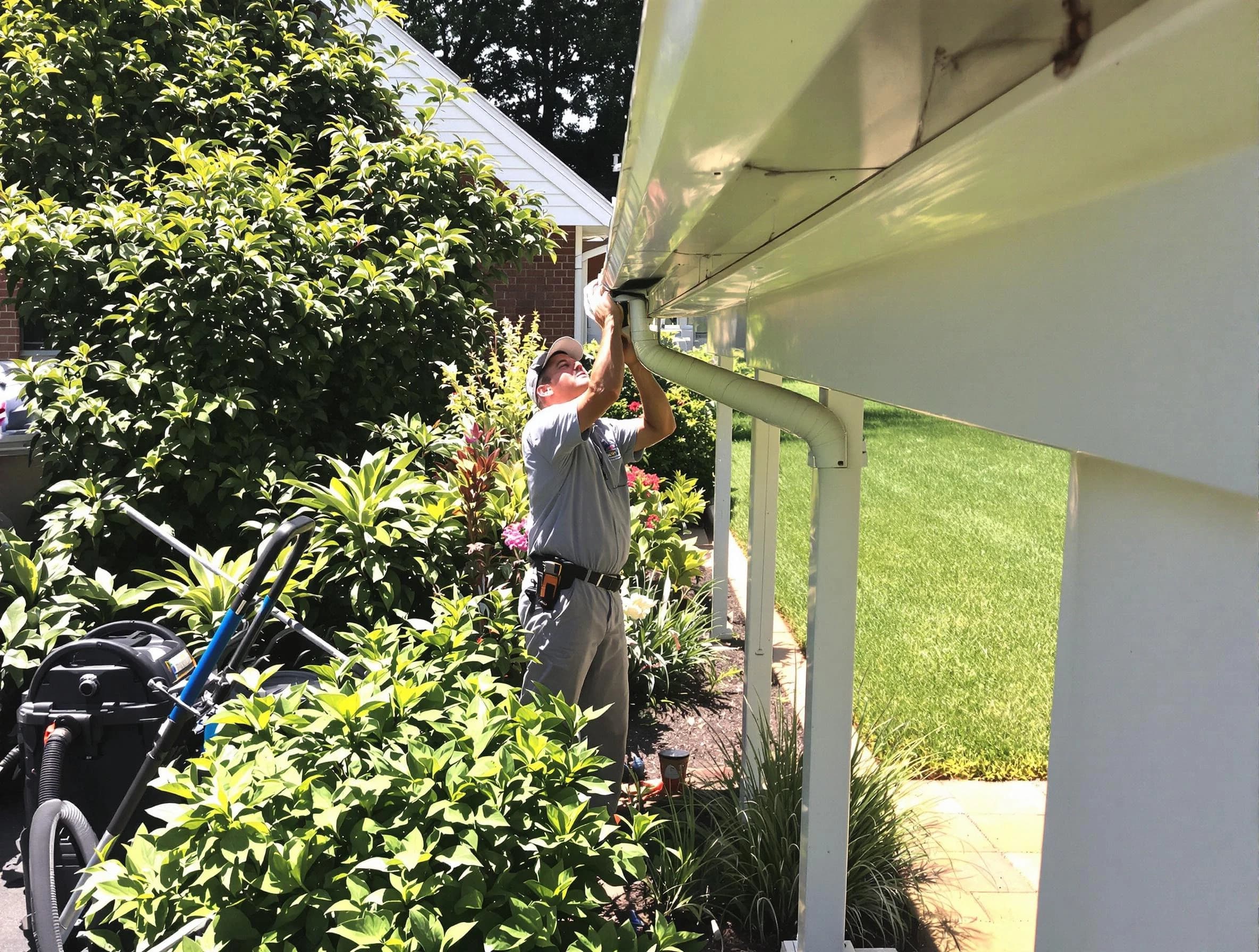 Technician flushing a blockage from a downspout in Medina, OH